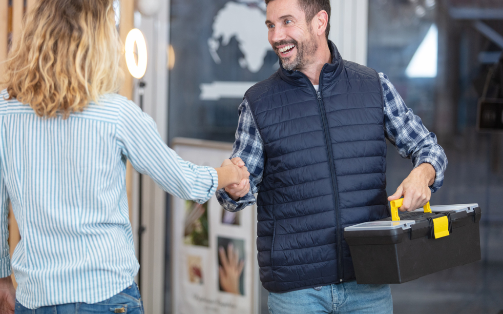 Plumber And Woman Shaking Hands At Home