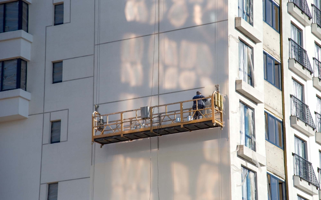 Workers Fixing Exterior Of Apartment Building