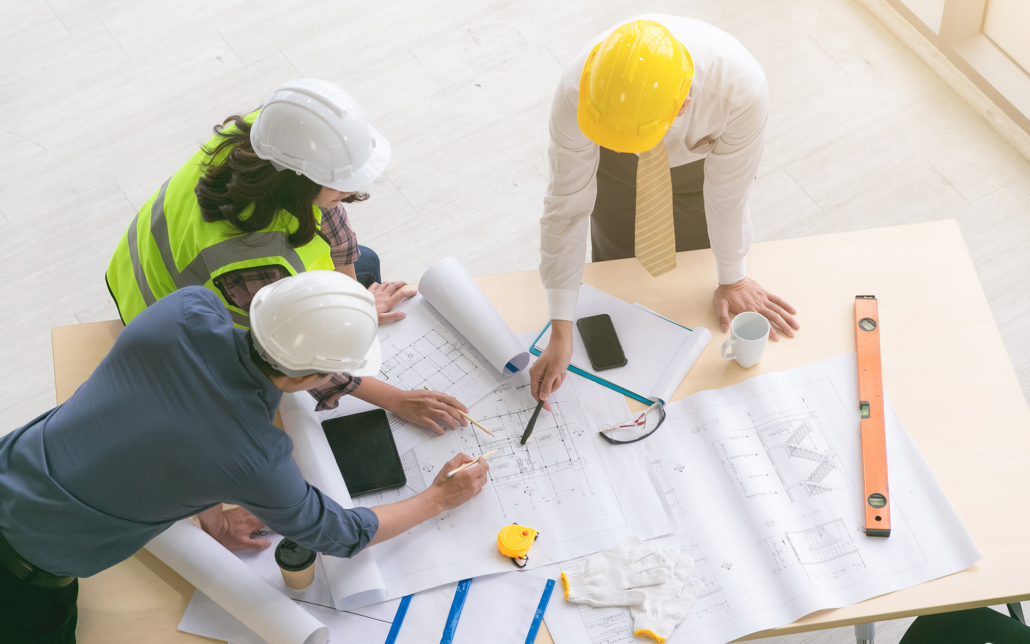 Group Of Workers Looking Over Construction Plans